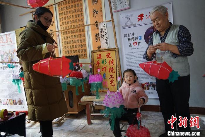 图为温存林和家人挂灯笼，庆祝元宵节。　郭惠民 摄