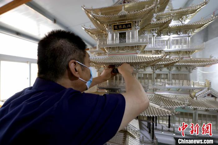 图为钳海强正在为滕王阁模型挂上牌匾。　沙飞 摄